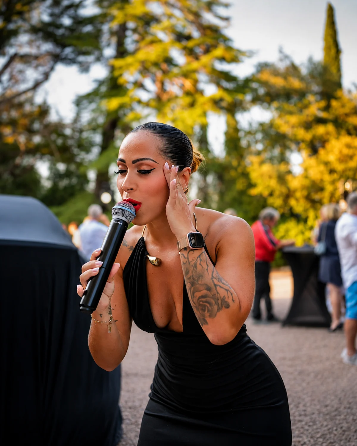 Chanteuse au micro lors d’un événement en extérieur.